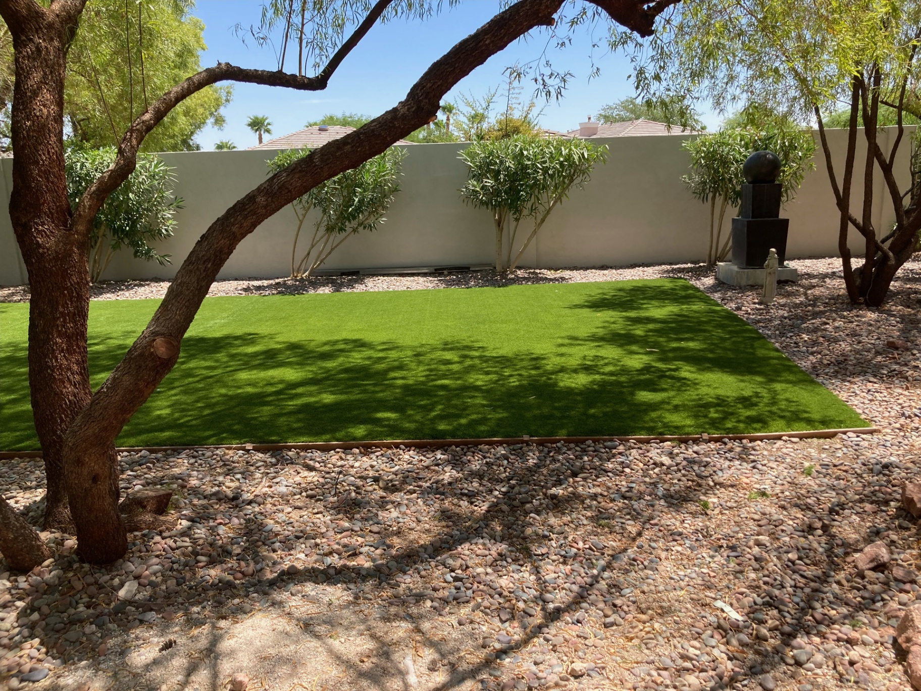 Courtyard turf panel set beneath mature trees with clean edging
