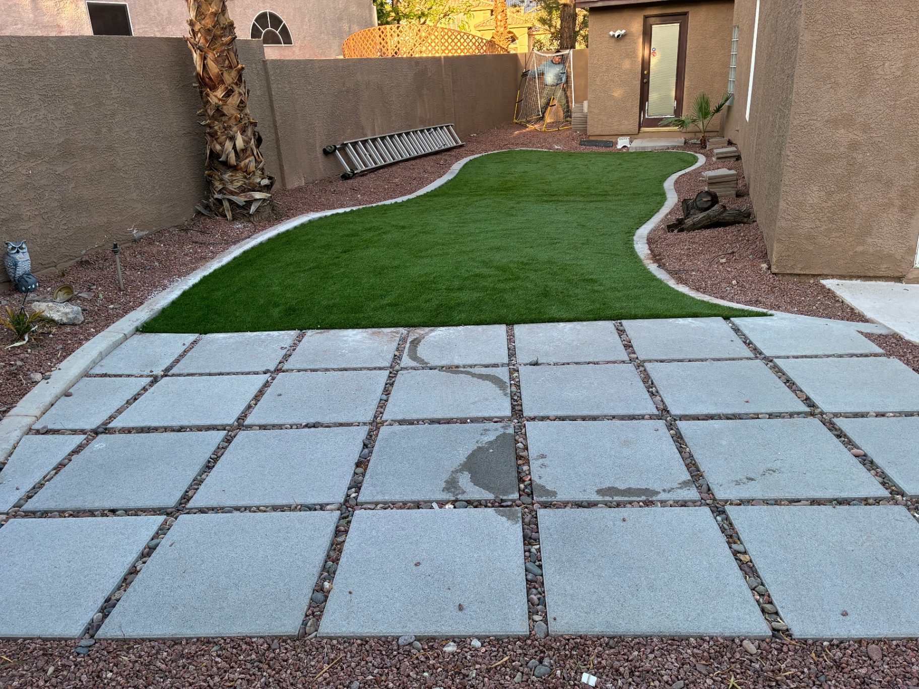 Curved artificial turf installation with paver patio