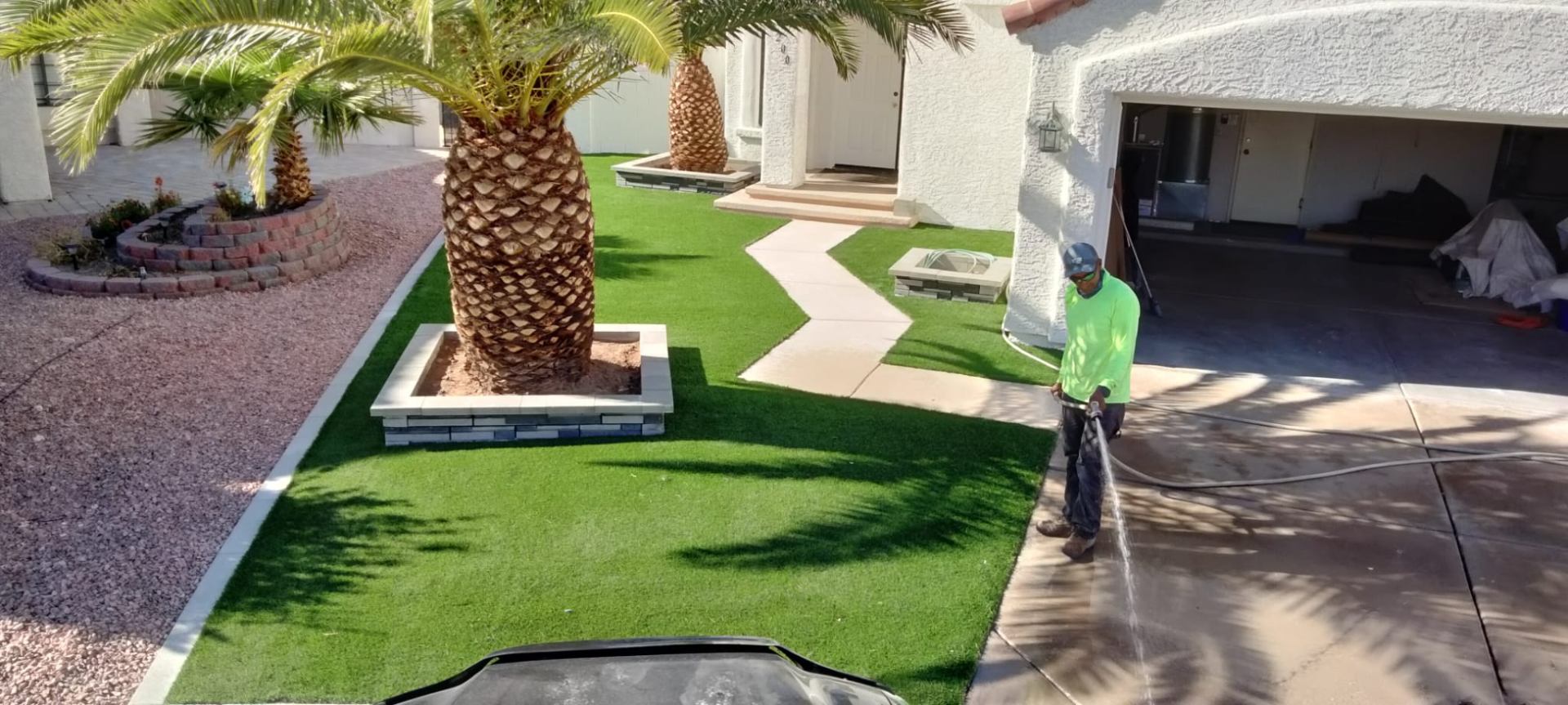 Landscape maintenance around artificial turf and palms